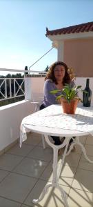 a woman sitting at a table on a balcony at Helena Inn in Svoronata