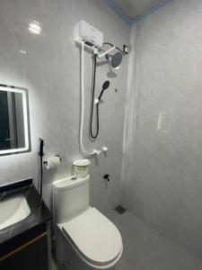 La salle de bains est pourvue d'une douche, de toilettes et d'un lavabo. dans l'établissement Cozy, Comfy Homestay, à Hithadhoo