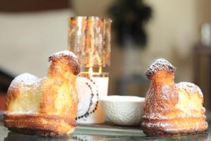 two donuts covered in powdered sugar sitting on a table at LA TOUR des fées-spa in Mittelbergheim