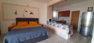 een slaapkamer met een bed met oranje kussens en een koelkast bij Apartments Vila Zagorje in Stinica