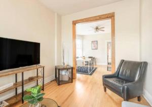 a living room with a television and a chair at The Roscoe Village Guesthouse in Chicago