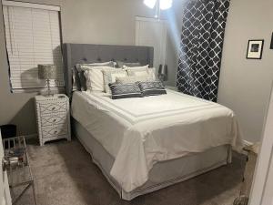 ein Schlafzimmer mit einem großen Bett mit weißer Bettwäsche und Kissen in der Unterkunft Sycamore Suite/ Wi-Fi & office in Big Spring