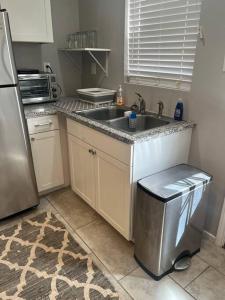 a kitchen with a sink and a refrigerator at Sycamore Suite/ Wi-Fi & office in Big Spring