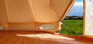 ein offenes Zelt mit einem Feld im Hintergrund in der Unterkunft Trevena Cross Bell Tent in Helston