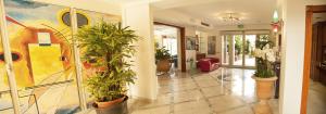 a hallway with potted plants and a painting on the wall at Residence Torre Del Mar in Alba Adriatica