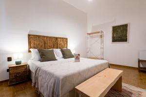 una camera da letto con un letto grande con testiera in legno di Sciaraqa a Mazara del Vallo