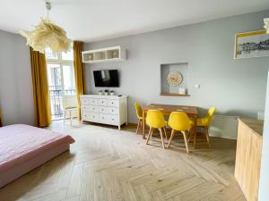 Schlafzimmer mit Esstisch und gelben Stühlen in der Unterkunft Top Residence Near Wawel in Krakau