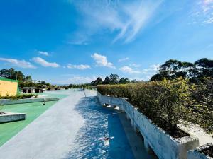 a walkway with bushes and a blue sky at Suite hotelera llanogrande in Rionegro