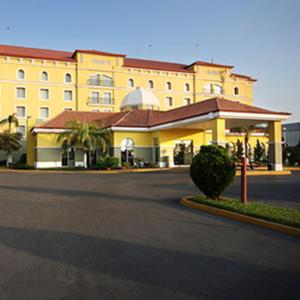 un grand bâtiment jaune avec une rue en face dans l'établissement Fiesta Inn Nuevo Laredo, à Nuevo Laredo