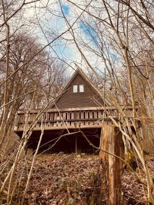 una casa in legno con un ponte nel bosco di The Forest Cabin Durbuy a Durbuy