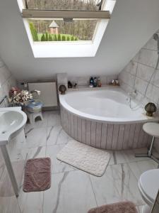 a bathroom with a large tub and a sink at Green Dream Apartment 5 persons free sauna in Miskolc +29 photos