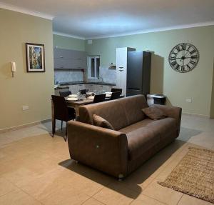 a living room with a couch and a table with a clock at Susannah's Place in Żejtun