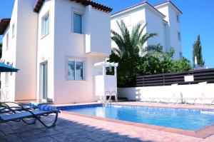 a villa with a swimming pool in front of a house at Villa millie Cyprus in Protaras