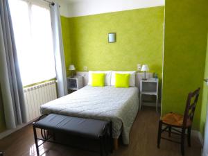 a bedroom with a bed with lime green walls at Hotel Au Petit Béarn in Salies-de-Béarn