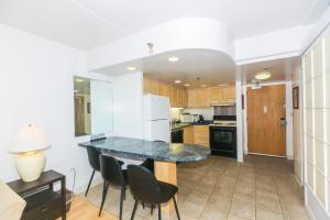 une cuisine avec une table et des chaises dans une pièce dans l'établissement Ilikai Tower 1936 condo, à Honolulu 20 autres photos