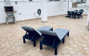 un grupo de sillas y mesas en una habitación en Ático Conil Playa con piscina, parking, 2 terrazas-BBQ, Aire Ac y WIFI -SOLO FAMILIAS Y PAREJAS- en Conil de la Frontera