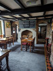 a dining room with tables and chairs and a fireplace at George Inn st briavels in Lydney