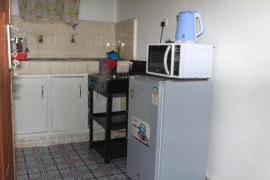 a kitchen with a microwave on top of a refrigerator at Chaka Airbnb. in Nyeri