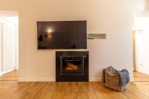 uma sala de estar com lareira e televisão na parede em Cavallotti 22 em La Spezia