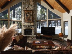 a living room with a stone fireplace and a television at Cobalt Cabin Gateway to Grand Canyon Sedona & More in Williams