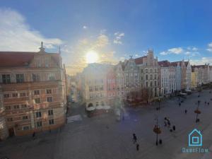 a view of a city with the sun setting behind buildings at Danzig Room in Gdańsk