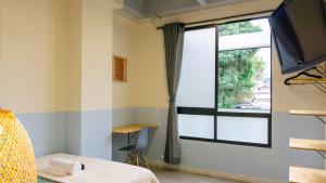 a bedroom with a window and a bed and a desk at Selva House in Medellín