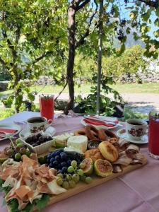 a plate of food on a table with grapes and cheese at Sailor's Rustic House in Virpazar