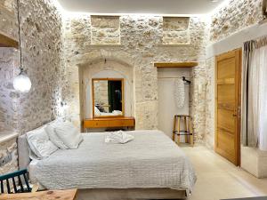 a bedroom with a bed and a stone wall at Barbara Studios in Rethymno