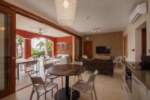 a living room with a table and chairs at La Maya Beach Curacao in Willemstad