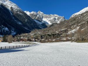 a snow covered mountain with houses and a fence at Walliser Stadel in Fieschertal