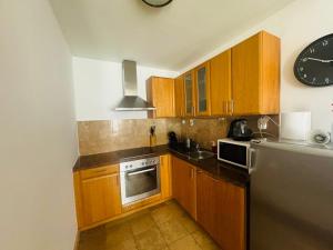 a kitchen with wooden cabinets and a stainless steel refrigerator at K3 in Budapest