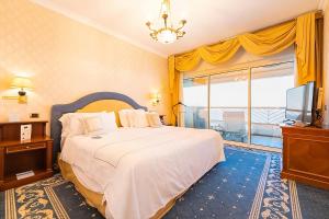 um quarto com uma cama grande e uma televisão em Grand Hotel Del Mare Resort & Spa em Bordighera