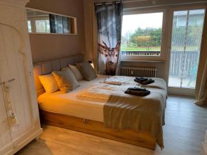 a bed in a bedroom with a large window at Ferienwohnung Darosa Gipfelglück in Seeg