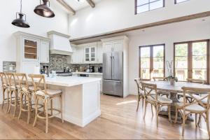 a kitchen with a table and chairs and a refrigerator at Exquisite luxury executive cottages in Woodside