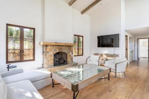 a living room with a table and a fireplace at Exquisite luxury executive cottages in Woodside