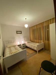 1 Schlafzimmer mit 2 Betten, einem Tisch und einem Stuhl in der Unterkunft Kuća za odmor VB-IDRO in Tuhelj