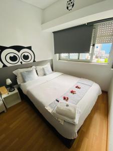 um quarto com uma cama grande com flores vermelhas em Corujinha Hostel em Lisboa