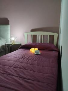 a purple bed with a plate of food on it at La ninfa B&B in Salerno