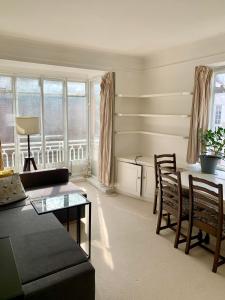 a living room with a couch and a table and chairs at Cozy Entire Flat walking to Hyde Park in London
