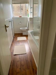 a bathroom with a toilet and a tub and a sink at Cozy Entire Flat walking to Hyde Park in London