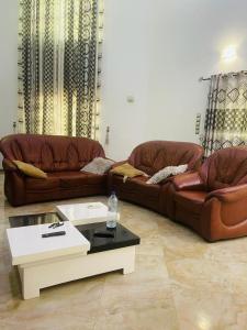 a living room with two couches and a coffee table at Coquet appart in Abomey-Calavi