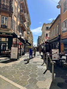 Eine Stadtstraße mit Leuten, die die Straße entlang laufen in der Unterkunft Carre D'or: Very Central Calm Cozy 2BR, with Wi-Fi in Nizza