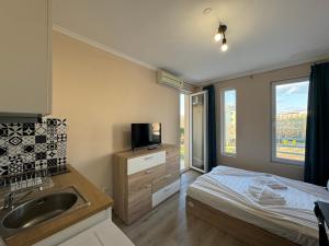 a bedroom with a bed and a sink and a television at VIP Vision STUDIO 409 Sunny Beach in Sunny Beach