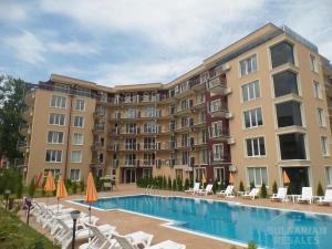a large apartment building with a swimming pool and chairs at VIP Vision STUDIO 409 Sunny Beach in Sunny Beach