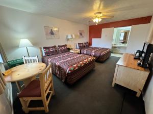 Habitación de hotel con 2 camas y mesa en Vista Del Rio Lodge, en Chama