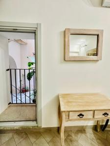 a mirror and a wooden table in a room at San Lorenzo Room in Trapani