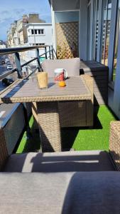 stolik na balkonie z filiżanką kawy i pomarańczą w obiekcie Un extérieur en ville w mieście Cherbourg en Cotentin