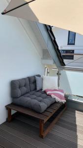 un sofá en la parte superior de una habitación con una escalera en Ferienwohnung - nah an Phantasialand, Köln & Bonn, en Weilerswist