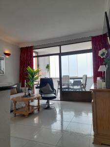 een woonkamer met een stoel en een tafel bij Luxury private apartment at the beach in a 4 star hotel first beach line in Fuengirola