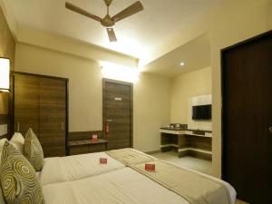 Schlafzimmer mit einem Bett und einem Deckenventilator in der Unterkunft Admiral Inn Suites in Neu-Delhi